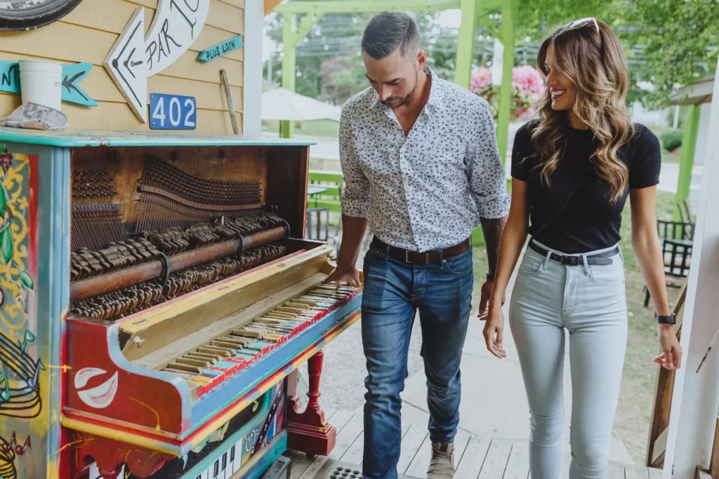 Two guests walk past the painted piano at the front of 402 Main Street